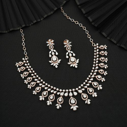 Elegant gold and diamond bridal necklace set with intricate teardrop and floral designs, accompanied by matching earrings, displayed on a black background