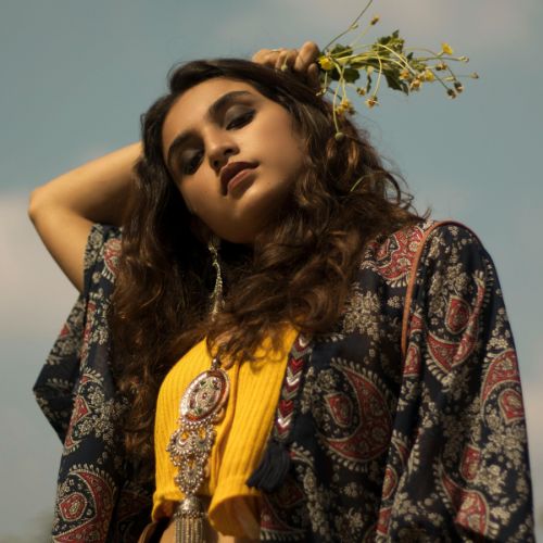  A woman wearing a yellow top paired with a blue and yellow printed kurta, showcasing vibrant colors and style.